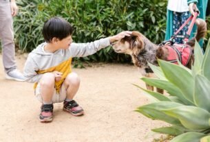 Smiling child petting a dog outdoors, highlighting companionship and joy.