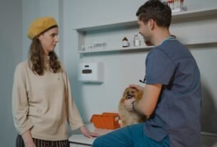 Veterinarian consulting with dog owner in a clinic while holding a Pomeranian.